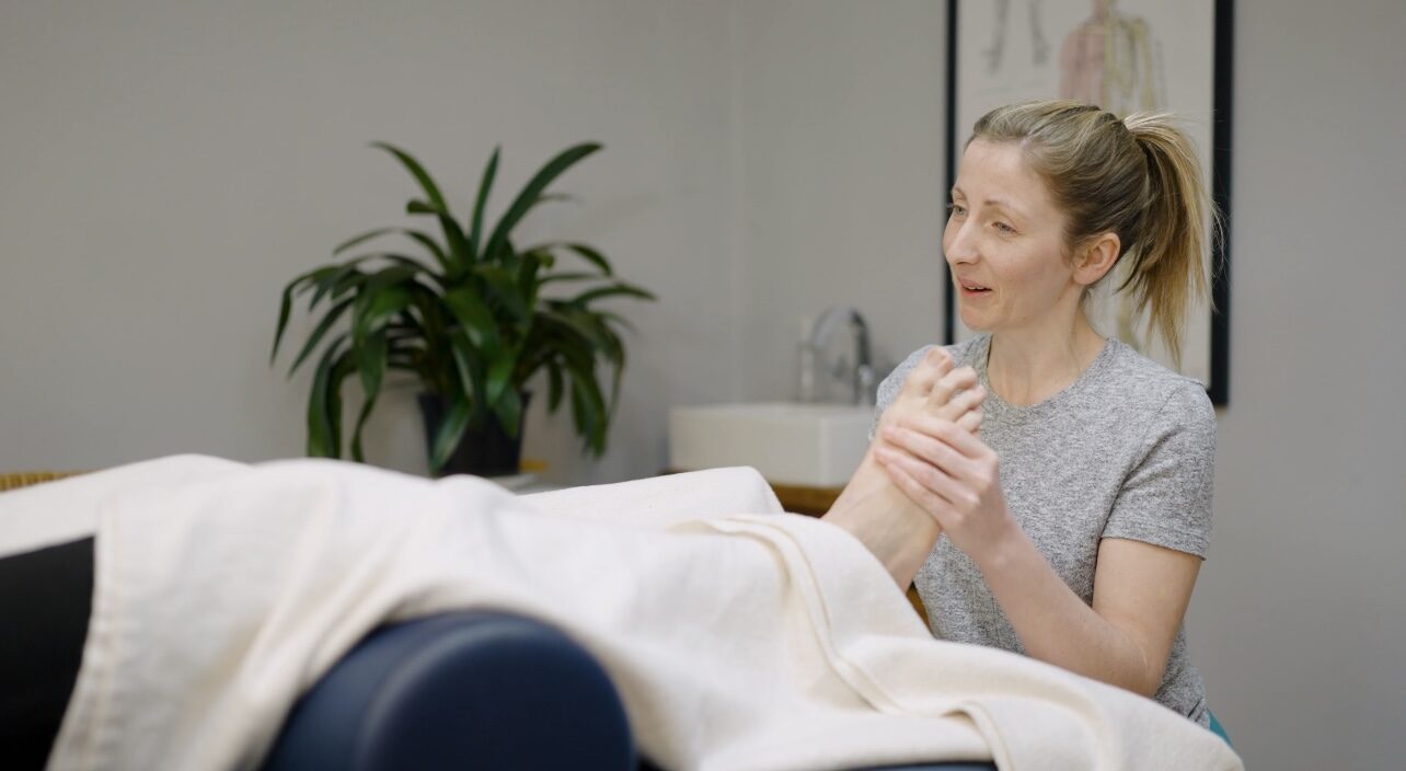 Olivia at Well Bath, holding a reflexology session.
